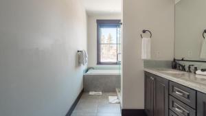 a bathroom with a tub and a sink and a window at Maple by AvantStay Modern Mountain Home w Cozy Fire Pit 15 Mins frm Northstar in Ponderosa Fairway Estates +27 photos