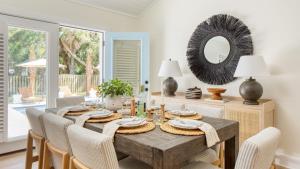 a dining room with a table with chairs and a mirror at Sawyer by AvantStay Stunning Isle Of Palms Home w Pool in Isle of Palms