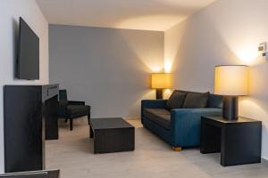 Una sala de estar con un sofá azul y un televisor. en Fiesta Inn Tepic, en Tepic
