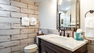 a bathroom with a sink and a toilet and a mirror at Etta Place 5 by AvantStay Ski In Ski Out Unit w Views of the Valley in Telluride