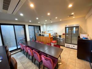 a dining room with a table and pink chairs at Omori Happy Smile Hotel-Self Check In in Tokyo