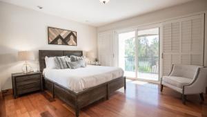 a bedroom with a bed and a chair and a window at De Luz by AvantStay 5 Acre Estate w Lake Pool Hot Tub in Murrieta