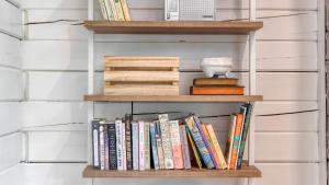a book shelf filled with books on a wall at Half Moon by AvantStay 4BR Cabin w Large Deck Yard w Patio Outdoor Dining in Great Barrington
