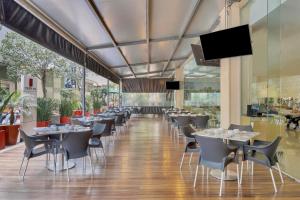a restaurant with tables and chairs in a building at Fiesta Inn Insurgentes Sur in Mexico City