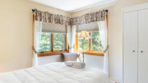a bedroom with a bed and two windows at Cimarron Lodge 14 by AvantStay Ski-InSki-Out Property in Complex w Two Hot Tubs Permit3601 in Telluride
