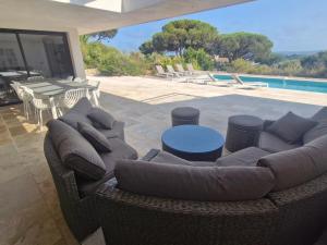 un canapé assis sur une terrasse à côté d'une piscine dans l'établissement Villa climatisée 6 pièces avec piscine privée, 5 chambres, Domaine de La Nartelle - FR-1-780-67, à Sainte-Maxime