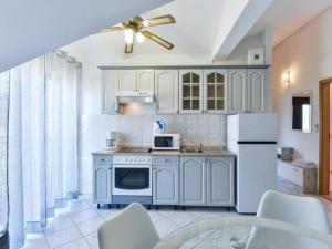 una cucina con elettrodomestici bianchi e un ventilatore a soffitto di Apartments Franica with Heated Pool and Hot-Tub - One Bedroom Apartment with Balcony a Privlaka (Brevilacqua)