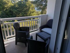 a balcony with chairs and a chair and a window at Apartments Libertas - Studio with Balcony and Sea View - 3 in Rogoznica