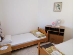 a bedroom with two beds and a dresser in it at Apartments Libertas - Studio with Balcony and Sea View - 3 in Rogoznica