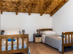two beds in a room with wooden ceilings at Holiday Home Stari Dvori in Podumci +23 photos