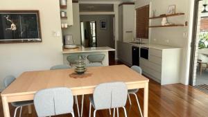 une cuisine et une salle à manger avec une table et des chaises en bois dans l'établissement Monterra Ave Magic, à Hawks Nest