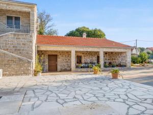 a building with a stone driveway in front of it at Holiday Home Stari Dvori in Podumci