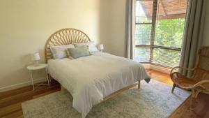 une chambre avec un lit et une grande fenêtre dans l'établissement Monterra Ave Magic, à Hawks Nest 9 autres photos