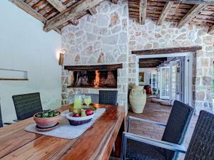 a dining room with a table and a stone fireplace at Stone House Anfitrite - Two Bedroom Villa with Private Pool and Terrace in Trstenik