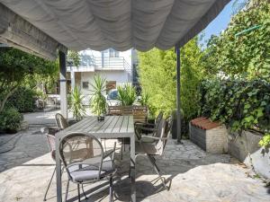 a patio with a table and chairs under a canopy at One-Bedroom Apartment With Pool in Brodarica