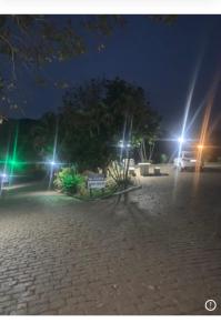 Un parque de noche con farolas y un banco. en Pousada Flat Royal - Flat 03, en Itapecerica