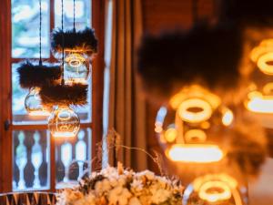 Una mesa con luces y flores frente a una ventana. en Chalet exquis à Courchevel 1850, près des pistes, jusqu'à 10 personnes - FR-1-772-5, en Courchevel