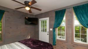 a bedroom with wooden walls and a ceiling fan at Honeycomb Hideaway by AvantStay Rustic Retreat in Fairview