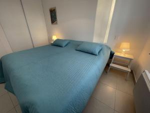 a small bedroom with a blue bed and a chair at Appartement T3 PMR, 2 chambres, jardin privé, plage à pied, parking, internet 4G - FR-1-775-14 in Sarzeau