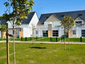 a group of trees in front of a building at Appartement T3 PMR, 2 chambres, jardin privé, plage à pied, parking, internet 4G - FR-1-775-14 in Sarzeau