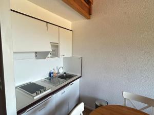 eine kleine Küche mit einem Waschbecken und einem Tisch in der Unterkunft Appartement duplex 4 pers, centre station, garage privé - FR-1-814-82 in Besse-et-Saint-Anastaise + 6 Fotos