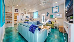 a living room with a blue couch and a table at Stella Maris by AvantStay Rooftop View Pool in Port Aransas