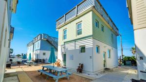 a building with a picnic table in front of it at Stella Maris by AvantStay Rooftop View Pool in Port Aransas