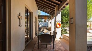 an outdoor dining room with a table and chairs at Villa del Gallo by AvantStay Luxury Group Retreat Pool Putting Green in Bermuda Dunes