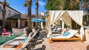 a pool with a bunch of lounge chairs and a swimming pool at Villa del Gallo by AvantStay Luxury Group Retreat Pool Putting Green in Bermuda Dunes