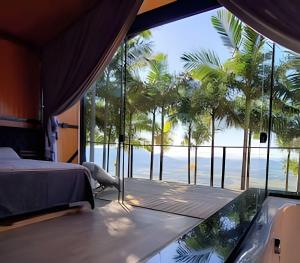 a bedroom with a view of the ocean at Cabana Vista Ilha/Santo Amaro da Imperatriz in Santo Amaro da Imperatriz