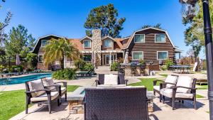 a house with a pool and chairs in the yard at Chateau Syrah by AvantStay Picturesque Estate w Pool Hot Tub Pool Table Table Tennis New Pickleball Court Basketball hoop in Temecula
