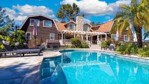 a house with a swimming pool in front of a house at Chateau Syrah by AvantStay Picturesque Estate w Pool Hot Tub Pool Table Table Tennis New Pickleball Court Basketball hoop in Temecula