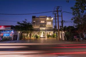 un bâtiment au bord d'une rue la nuit dans l'établissement Flex Suites, à Phum Pobos