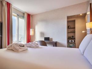a large white bed in a hotel room at Mercure Tour Eiffel Grenelle in Paris +68 photos