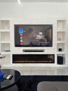 パラマリボにあるCozy home Northのリビングルーム(暖炉の上にテレビ付)