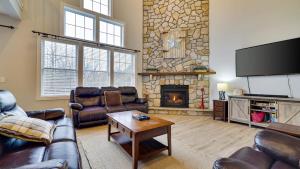 a living room with leather furniture and a stone fireplace at The Nest at Pinecrest by AvantStay Spacious Deck Game Room Fire Pit in Pocono Pines