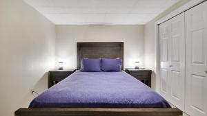 a bedroom with a purple bed with two night stands at The Nest at Pinecrest by AvantStay Spacious Deck Game Room Fire Pit in Pocono Pines +41 photos