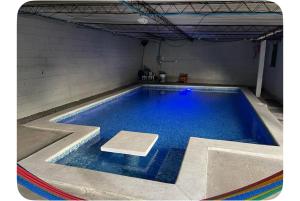 a large swimming pool with blue water in a room at Evolution Home in Las Flores