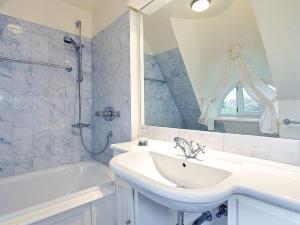 a bathroom with a sink and a tub and a mirror at Heidehaus in Kampen