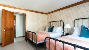 a bedroom with two beds and a door at Cathedral by AvantStay Charming Secluded Estate w Sauna Pool Table Views of the Rolling Hills in Paso Robles +40 photos