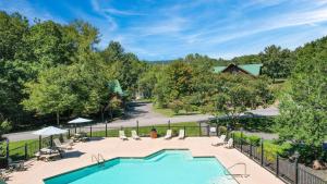 einen Blick über einen Pool mit einem Zaun in der Unterkunft Bluebell by AvantStay Incredible Views w Large Balcony Indoor Pool in Sevierville