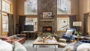 a living room with a couch and a fireplace at Highline by AvantStay Breathtaking Mountain Home w Hot Tub Views in Vail