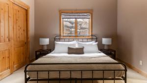 a bedroom with a bed with white pillows and a window at Highline by AvantStay Breathtaking Mountain Home w Hot Tub Views in Vail