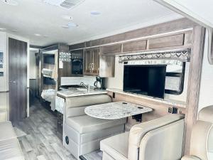 an rv kitchen with a sink and a tv at Farmhouse Rv - Sunset Pergola - Fire Pit - Views in Jacksonville