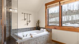 une baignoire dans une salle de bain avec une fenêtre dans l'établissement Russell Home by AvantStay Expansive Deck Stunning Views Hot Tub, à Telluride 24 autres photos