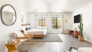 a bedroom with a bed and a mirror at Flora by AvantStay Modern Private Desert Oasis on Large Grounds w Pool Bocce Ball in Yucca Valley +48 photos