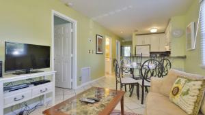 a living room with a couch and a tv and a table at Beach House Condo by AvantStay Communal Pool Gated Community Great Location Week Long Stays in Key West