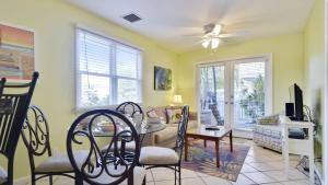 a living room with a table and chairs and a tv at Beach House Condo by AvantStay Communal Pool Gated Community Great Location Week Long Stays in Key West