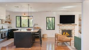 cocina con chimenea, mesa y TV en Silver Screen by AvantStay Luxe Backyard Escape, en Los Ángeles