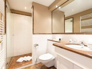 a bathroom with a toilet and a sink and a mirror at Prahl-Hues-1 in Kampen +8 photos